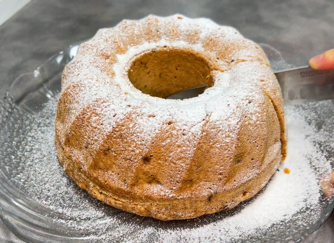 osoba seče kuglof sa suvih voćem