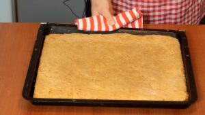 Pečena lenja pita sa jabukama u plehu, zlatno-smeđe kore, upravo izvađena iz rerne