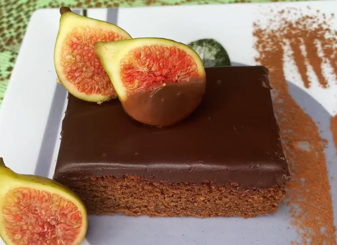 prikaz čokoladnog kolača na belom tanjiru sa dekoracijom od smokava i kakaa