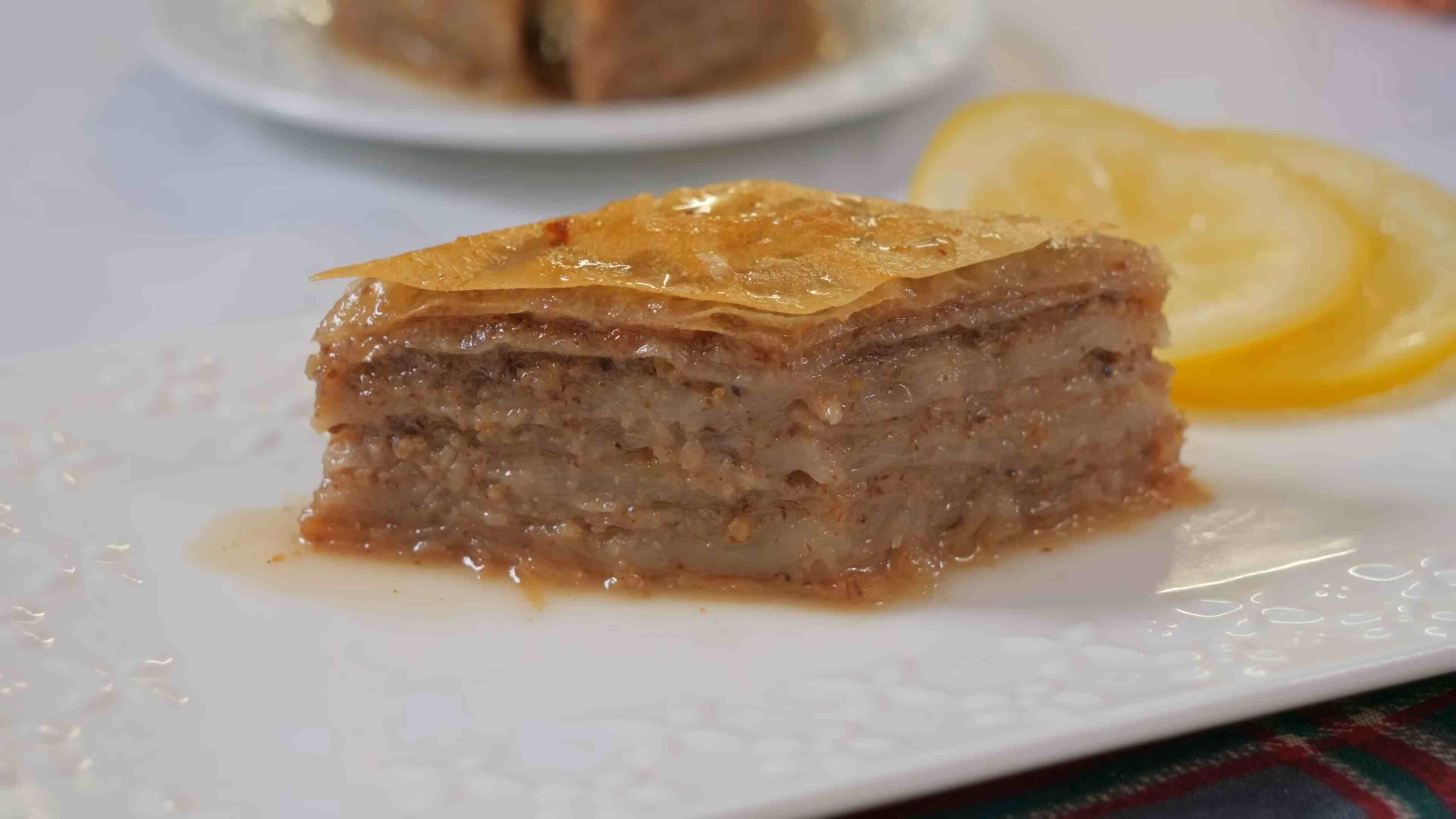 Parče baklave sa orasima u činiji sa kriškom limuna