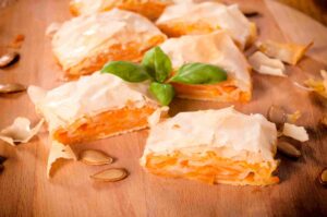 Parčići bundevarе na dasci, sa vidljivim slojevima kore i fila od bundeve