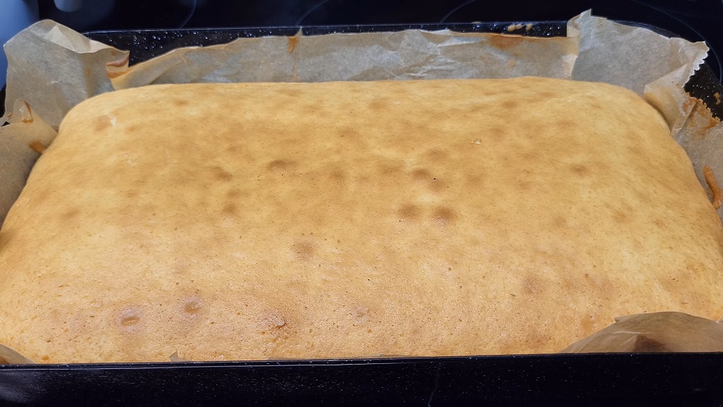 Ispečen biskvit u plehu spreman za sečenje na kocke za čupavce