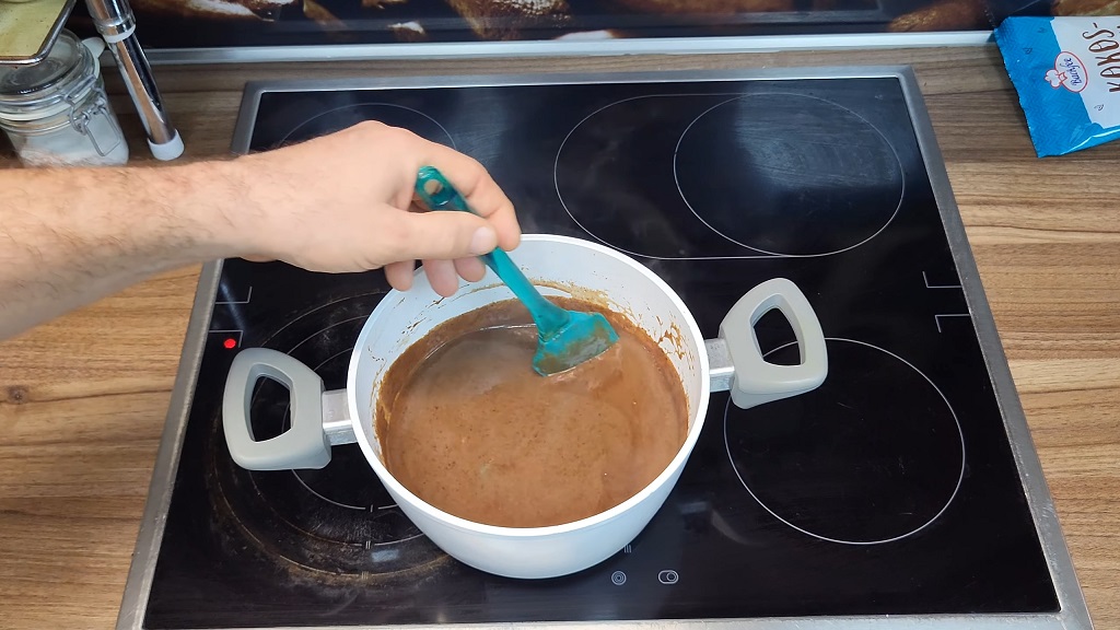 Mešanje čokoladnog preliva u šerpi na šporetu tokom pripreme čupavaca