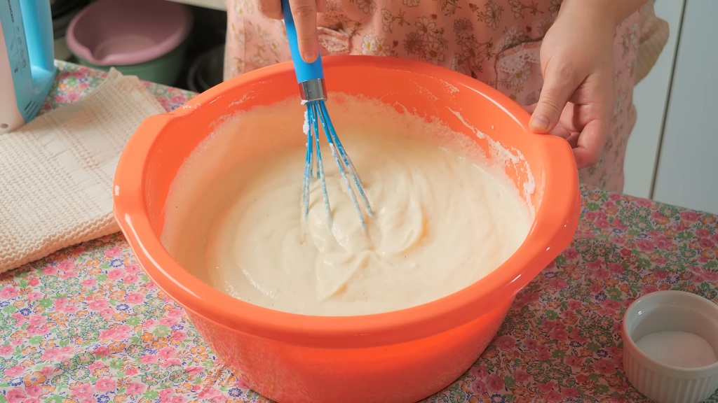 Umućeni vanila fil u činiji uz mešanje žicom tokom pripreme