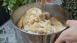 U velikoj činiji se mešaju mleveni orasi i pena od belanaca dok se ne dobije vazdušasta smesa za koru