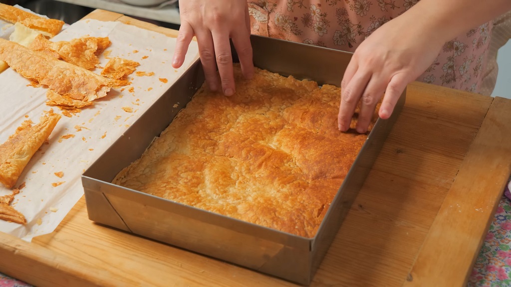 Pečeno lisnato testo u plehu koje se rukama ravna pre slaganja krempite