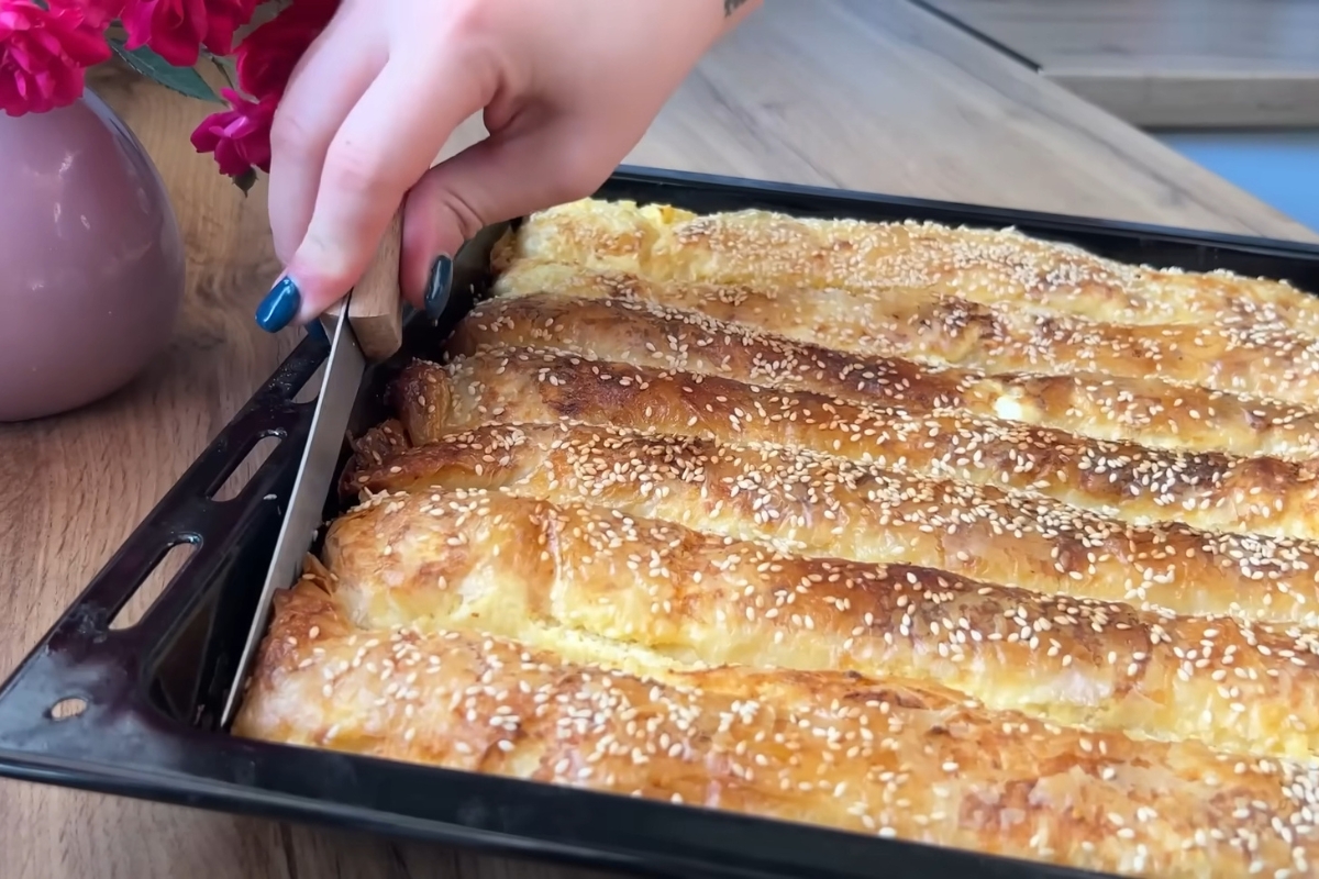 osoba seče pitu sa sirom