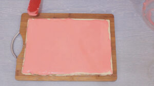 Nanošenje roze glazure na rozen tortu