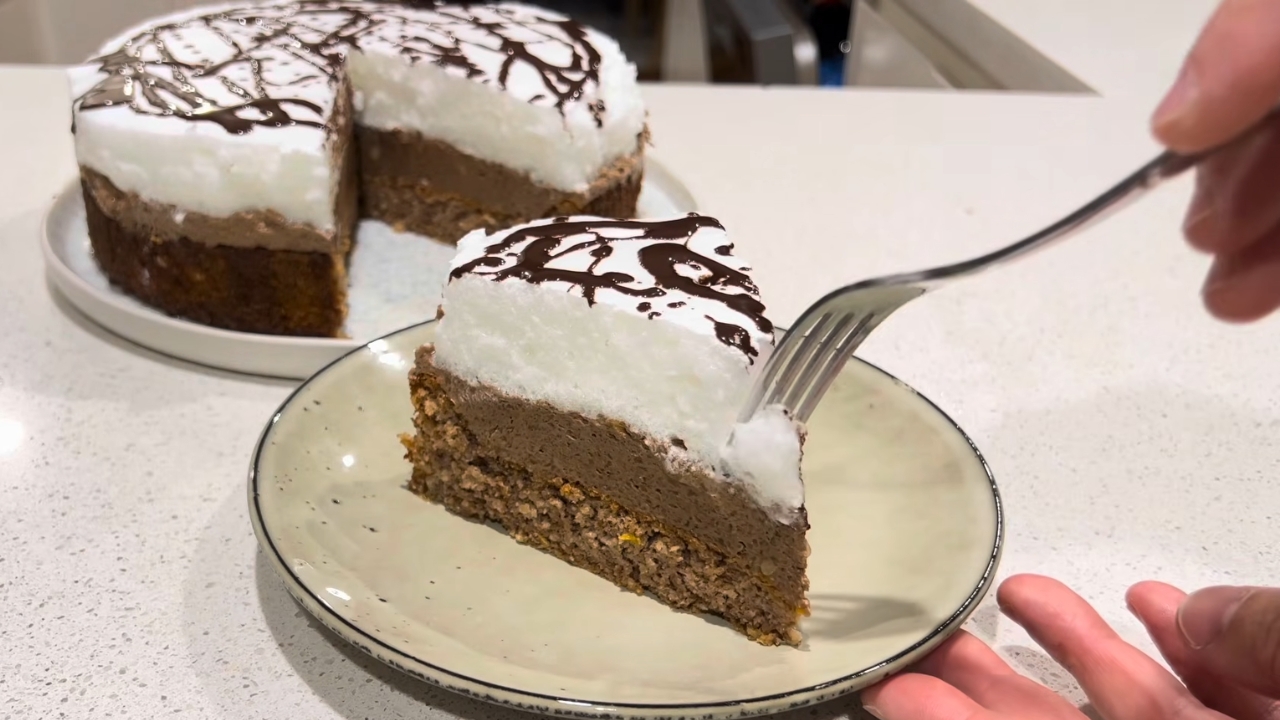 Parče Vasine torte sa čokoladnim filom, belim šaumom i dekoracijom od čokolade