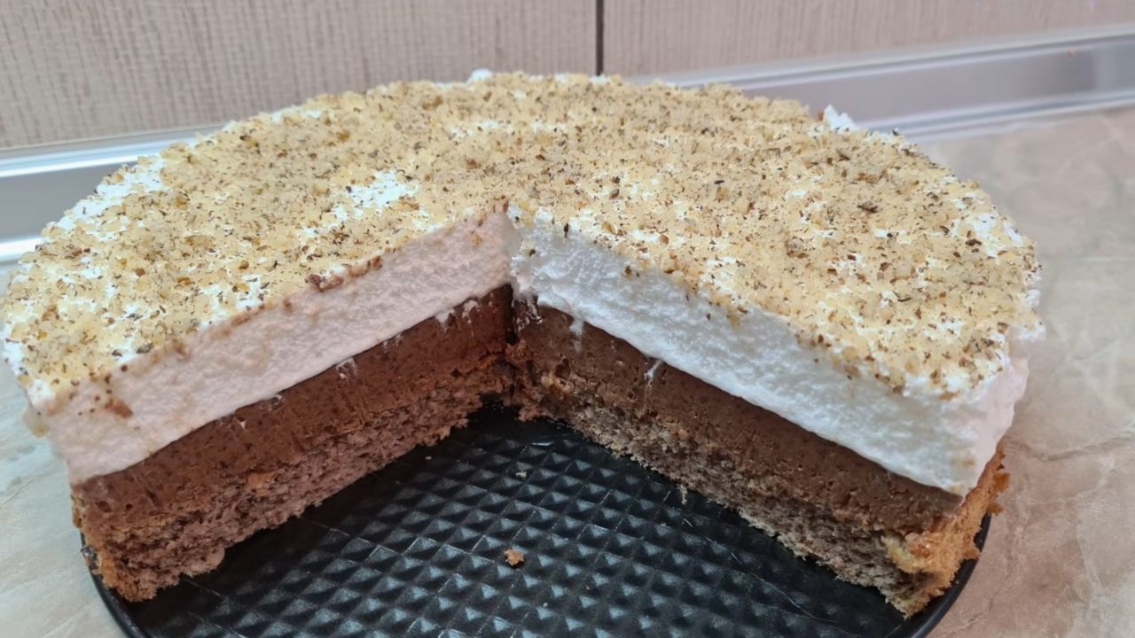 Vasina torta sa čokoladnim filom i belim šaumom, posuta mlevenim orasima