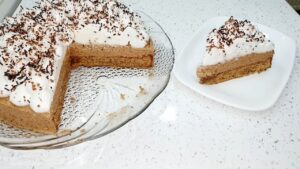 Presek Vasine torte sa bogatim kremom, korom i penastim šaumom posutim čokoladom.